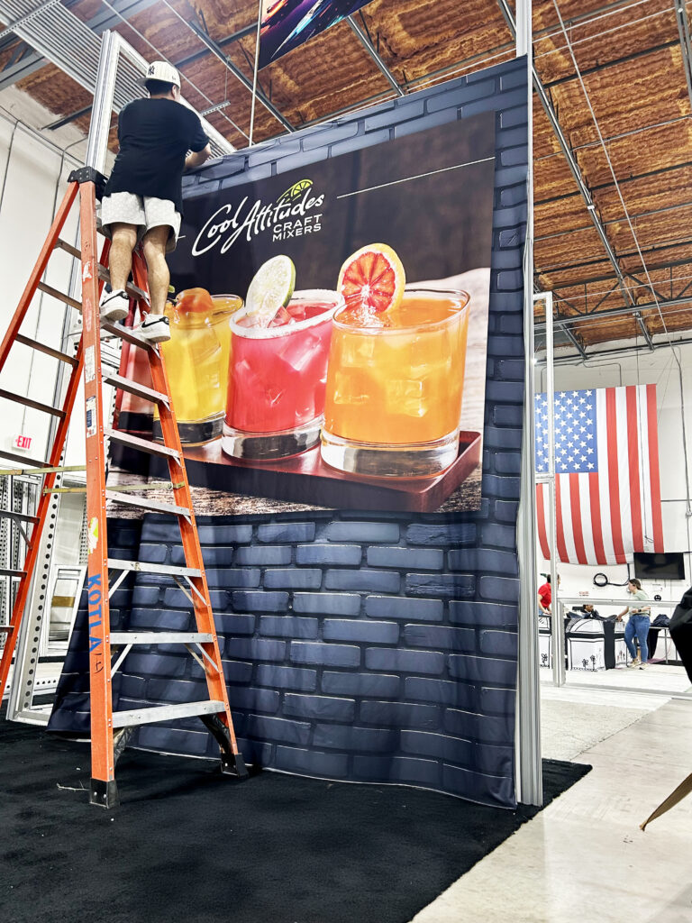 in-house-fitment-for-trade-show-booth-orlando Technician installing SEG graphics on BeMatrix frame during in-house trade show booth fitment in Orlando